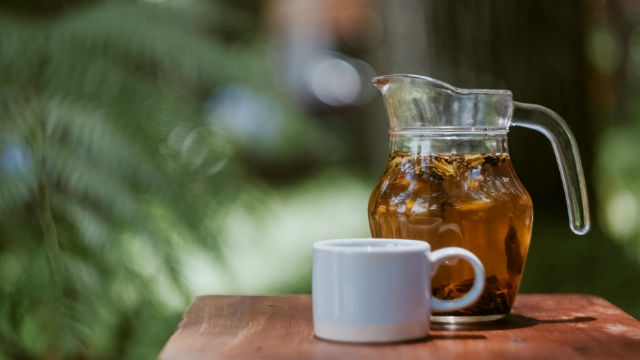 Durchsichtige Kanne mit Tasse Grüner Tee